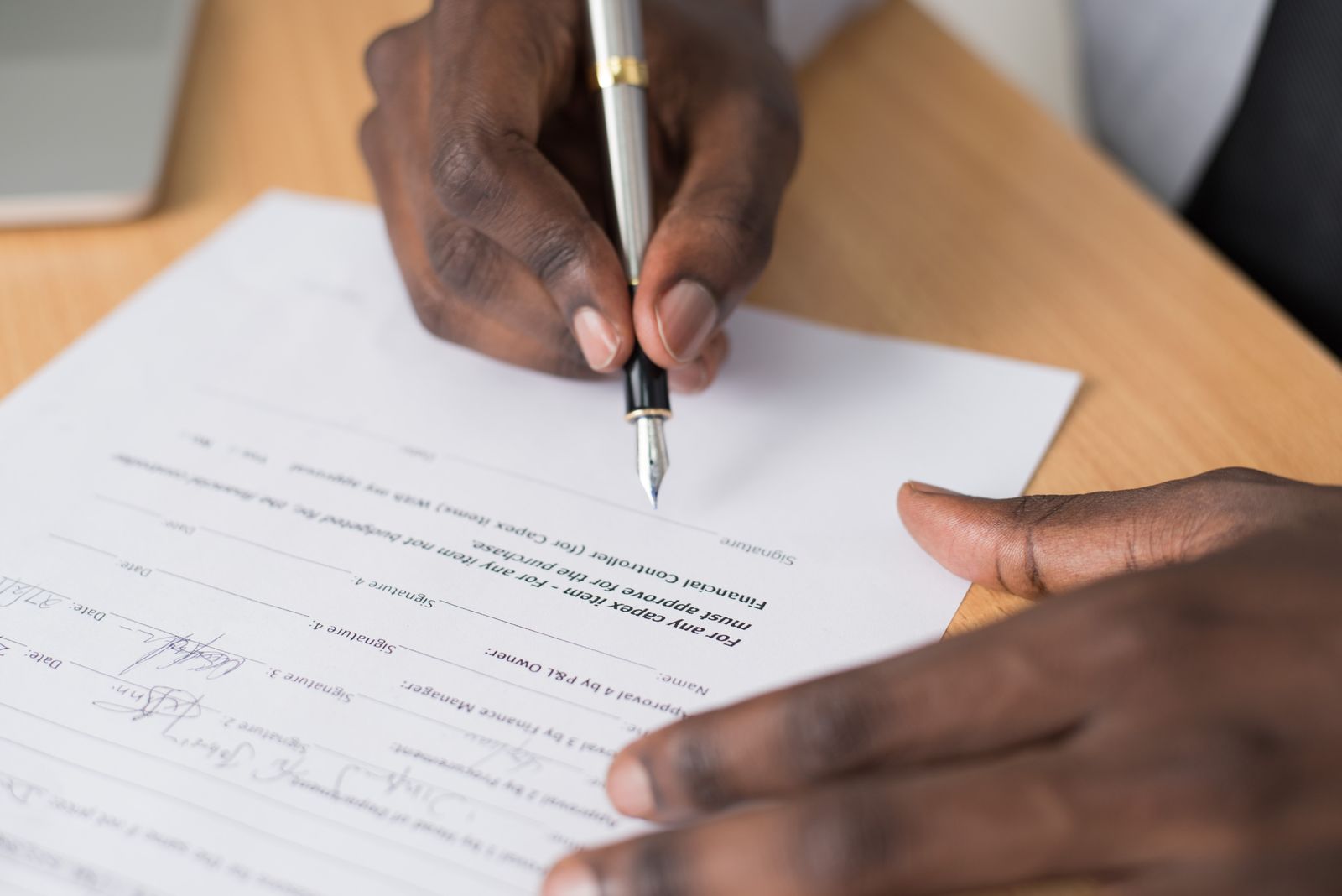 Signing loan documents at a settlement table